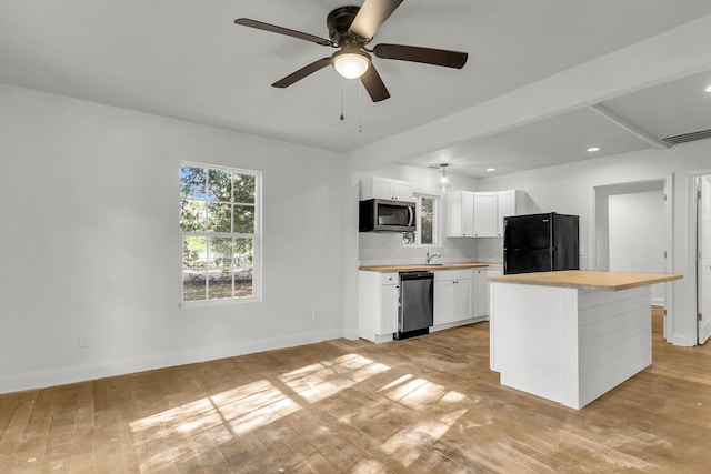 kitchen featuring a kitchen island, butcher block countertops, light hardwood / wood-style flooring, appliances with stainless steel finishes, and white cabinets