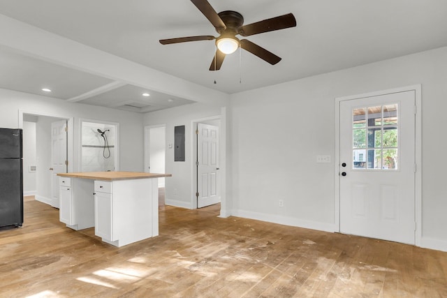 kitchen featuring wooden counters, white cabinetry, light hardwood / wood-style floors, and black refrigerator