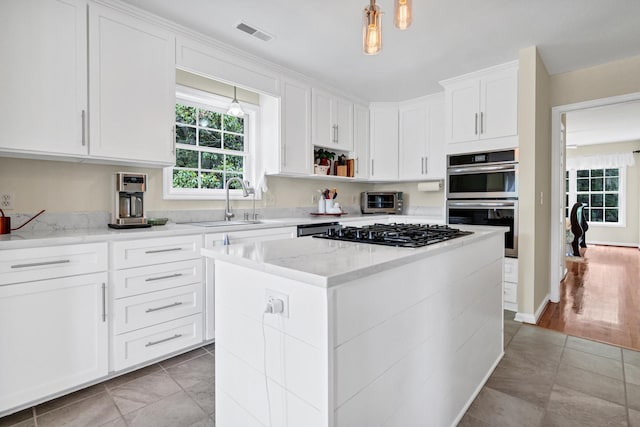 8346 Chisolm Plantation Rd, Edisto Island, SC 29438 - kitchen with gas cooktop, a sink, light tile patterned floors, double oven, and white cabinetry