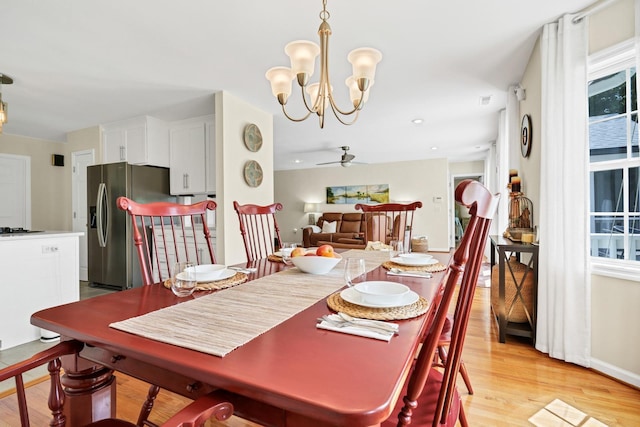 8346 Chisolm Plantation Rd, Edisto Island, SC 29438 - dining area with light wood-style flooring, a chandelier, and ceiling fan