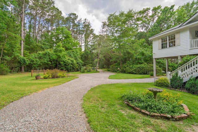 8346 Chisolm Plantation Rd, Edisto Island, SC 29438 - view of home's community featuring a lawn, gravel driveway, stairs, and view of scattered trees