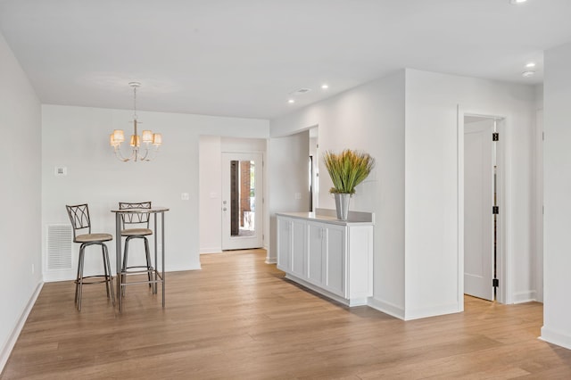 dining space with a chandelier and light wood-type flooring