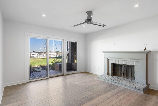 unfurnished living room with light hardwood / wood-style flooring, a fireplace, and ceiling fan