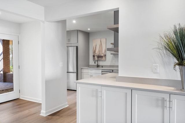 kitchen with stainless steel appliances, light hardwood / wood-style floors, and sink