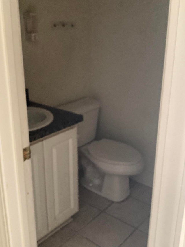 bathroom with tile floors, toilet, and vanity