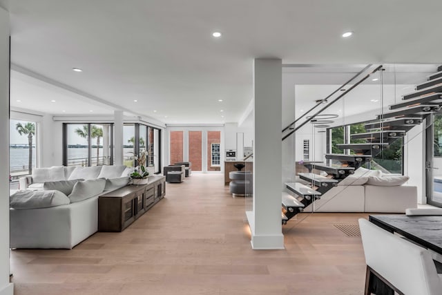 living room featuring light hardwood / wood-style flooring and a water view