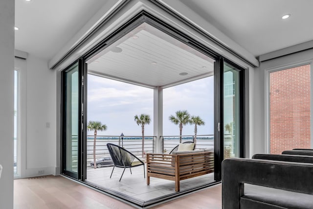 entryway with a water view and light hardwood / wood-style floors