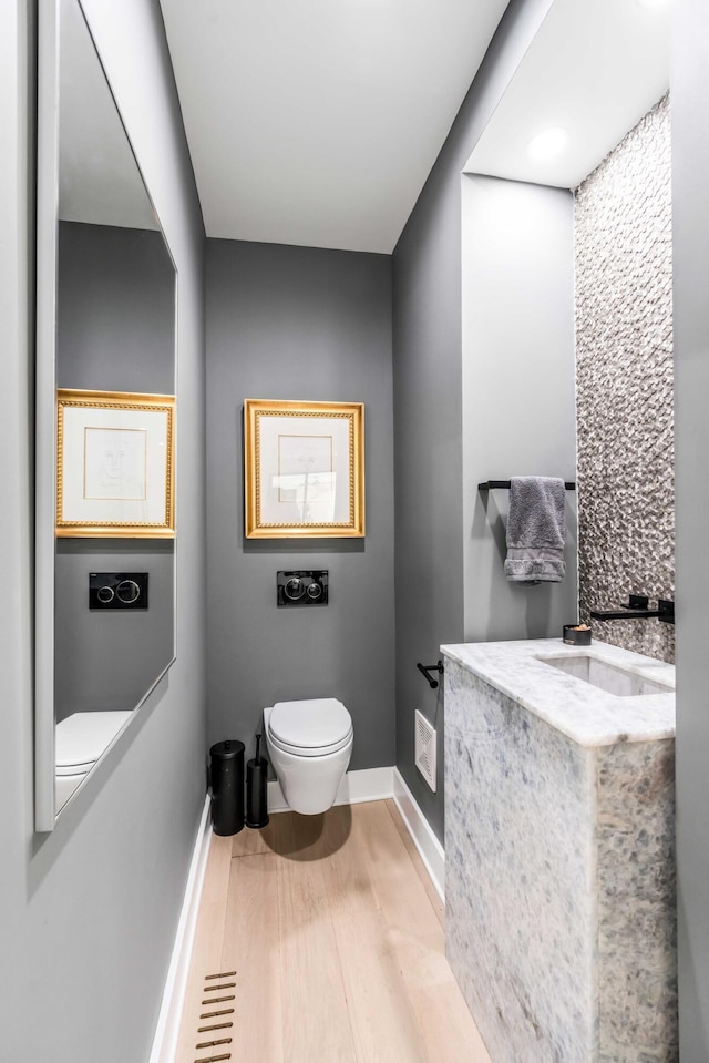 bathroom featuring hardwood / wood-style floors, sink, and toilet