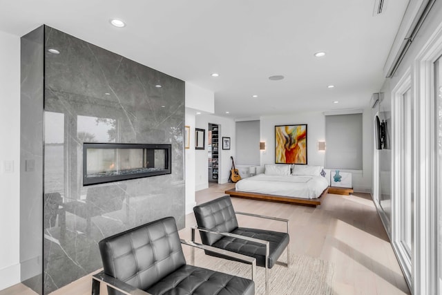 bedroom featuring tile walls, a fireplace, and light hardwood / wood-style floors