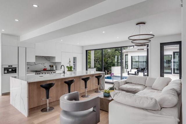 living room featuring sink and light hardwood / wood-style flooring