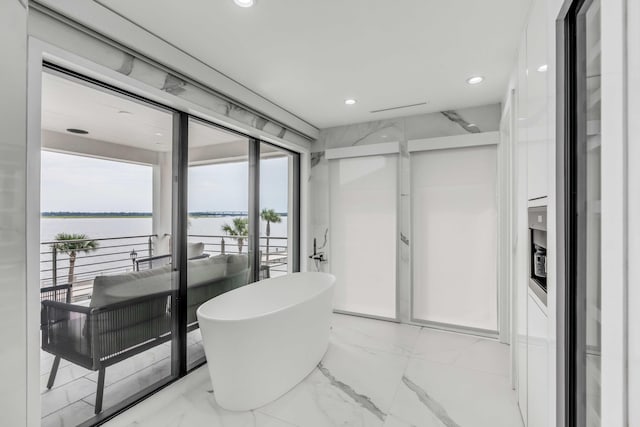 bathroom with a bathing tub and a water view