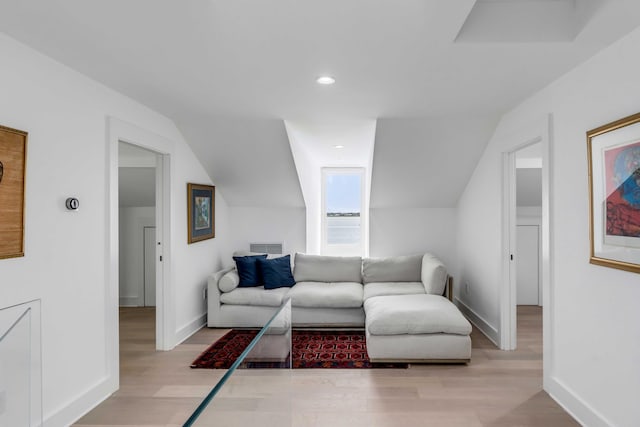 living room featuring lofted ceiling and light hardwood / wood-style floors