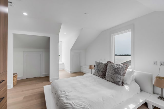 bedroom with lofted ceiling and light wood-type flooring