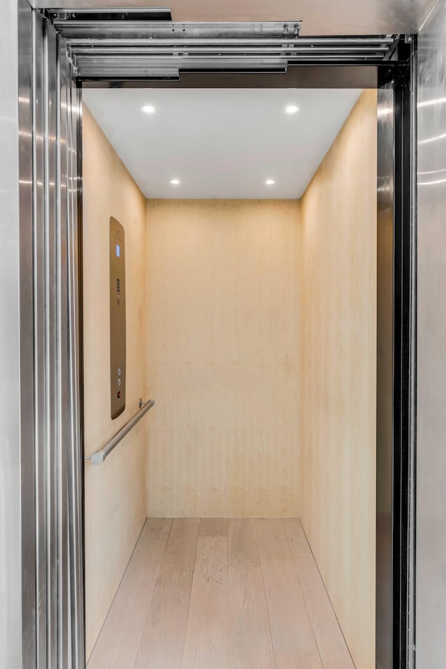 interior details with elevator and wood-type flooring