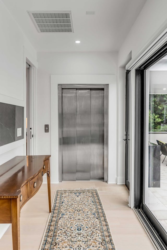 interior space featuring elevator and light wood-type flooring