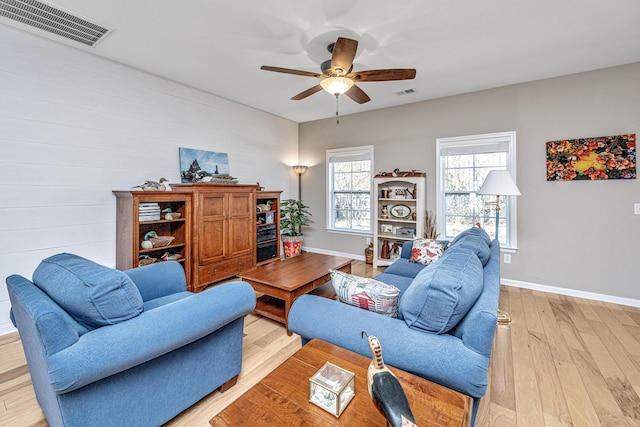 living room with light hardwood / wood-style flooring and ceiling fan