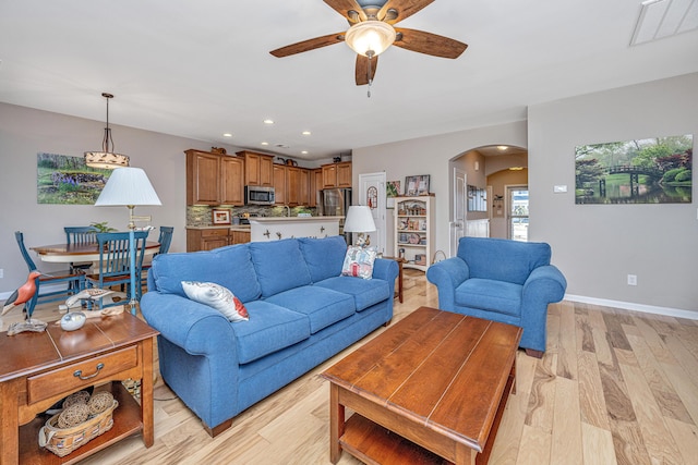 living room featuring ceiling fan and light wood-type flooring