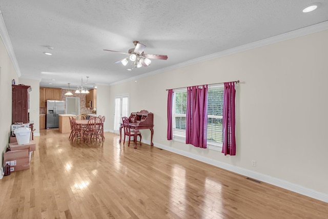 unfurnished living room with ornamental molding, a healthy amount of sunlight, and light wood-type flooring