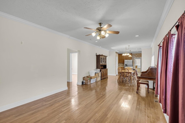 living room featuring wood-type flooring, ornamental molding, ceiling fan with notable chandelier, and a textured ceiling