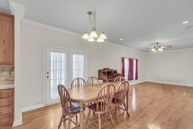 dining area with ornamental molding, ceiling fan with notable chandelier, and light wood-type flooring