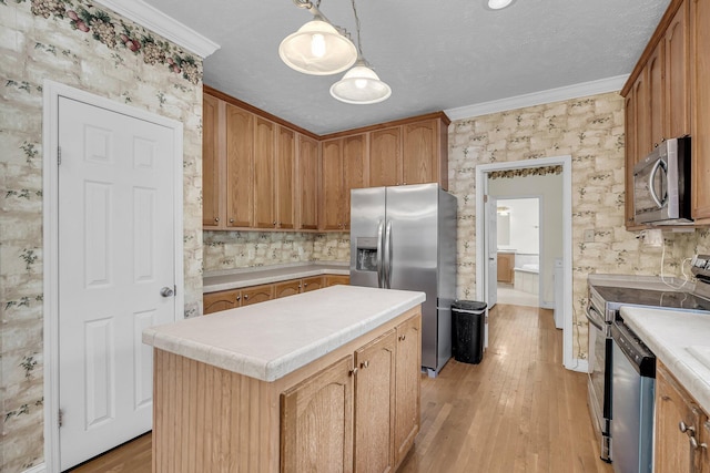 kitchen with hanging light fixtures, ornamental molding, appliances with stainless steel finishes, and a center island