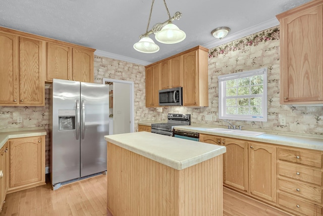 kitchen featuring sink, crown molding, hanging light fixtures, stainless steel appliances, and a kitchen island