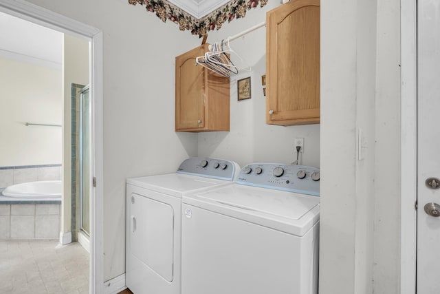 washroom with cabinets and washing machine and clothes dryer