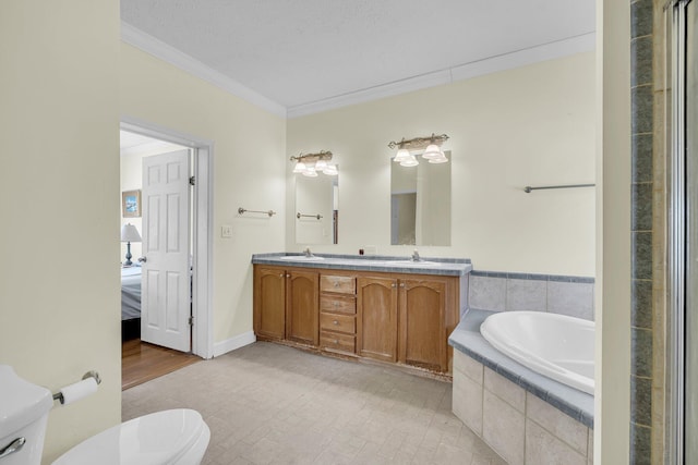 bathroom with vanity, toilet, tiled tub, crown molding, and a textured ceiling