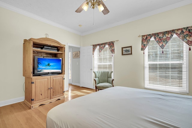 bedroom with crown molding, ceiling fan, and light hardwood / wood-style flooring