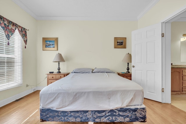 bedroom featuring connected bathroom, ornamental molding, and light hardwood / wood-style floors