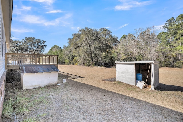 view of yard with a wooden deck and an outbuilding