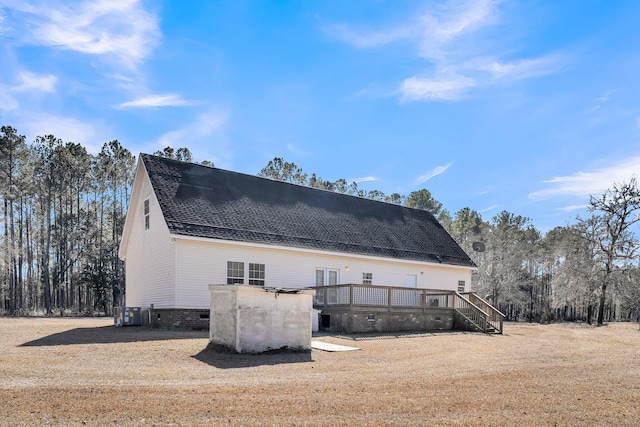 view of home's exterior featuring a wooden deck and a lawn