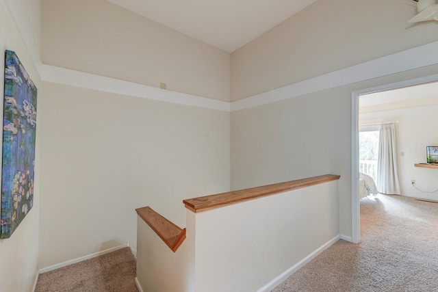 corridor with carpet, an upstairs landing, and baseboards