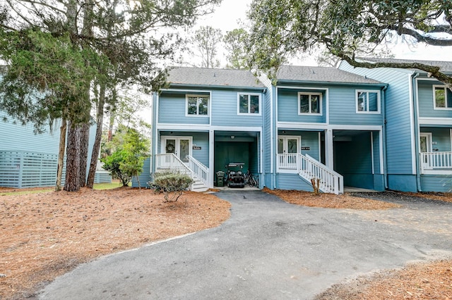 view of front of home with aphalt driveway, french doors, and a shingled roof