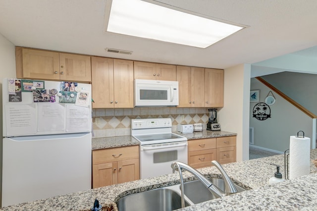 kitchen featuring white appliances, light brown cabinets, visible vents, a sink, and backsplash