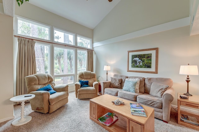 living area with baseboards, light colored carpet, high vaulted ceiling, and ceiling fan