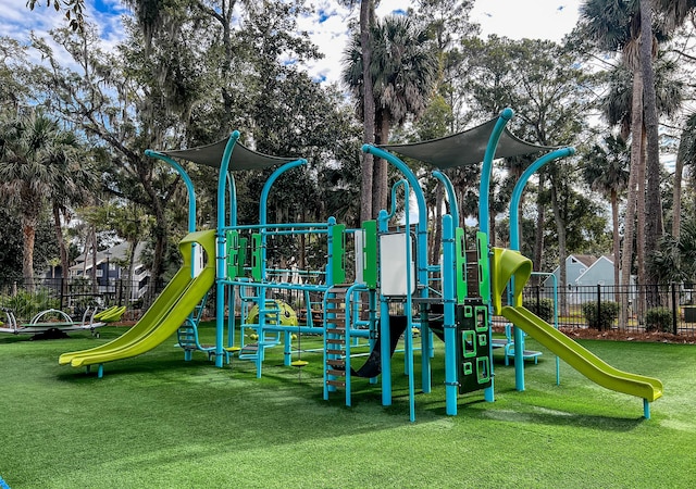 community playground featuring a yard and fence