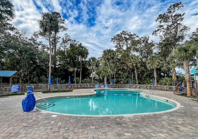 community pool with a patio and fence