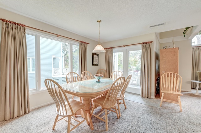 dining area with baseboards, visible vents, french doors, a textured ceiling, and light carpet