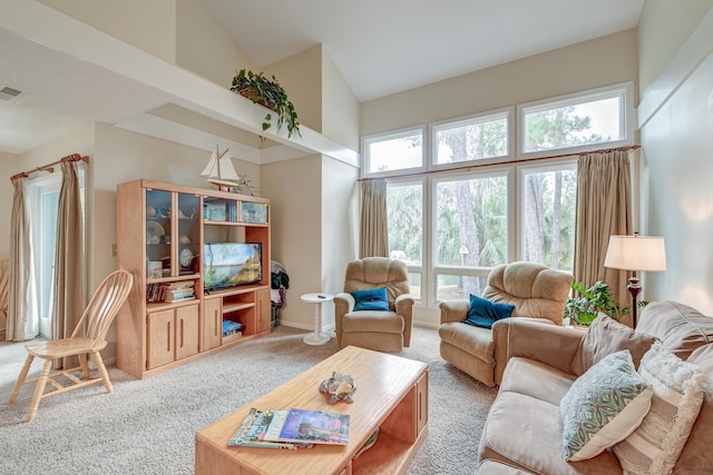 carpeted living room featuring visible vents, baseboards, and high vaulted ceiling