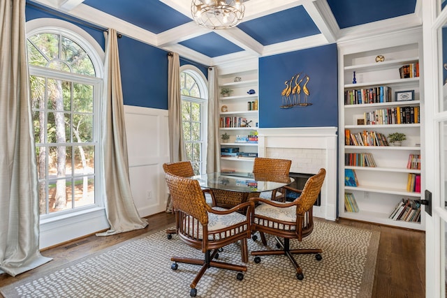 dining room with built in shelves, coffered ceiling, hardwood / wood-style floors, and crown molding