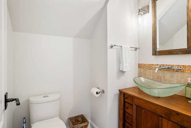 bathroom with vanity, lofted ceiling, and toilet