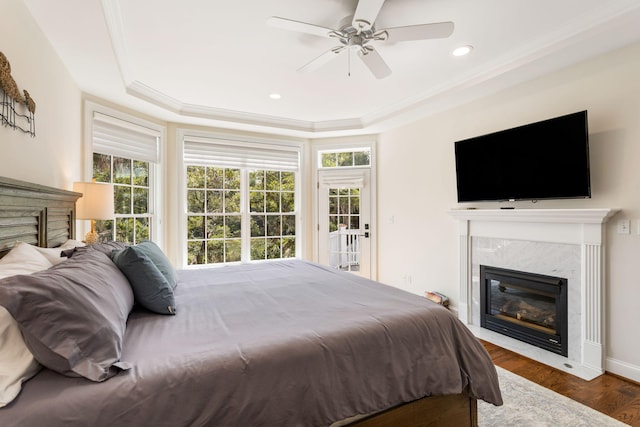 bedroom with a high end fireplace, multiple windows, and ceiling fan