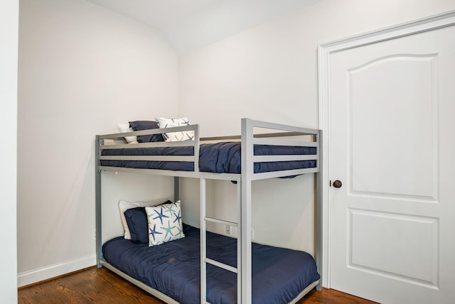 bedroom with lofted ceiling and dark wood-type flooring