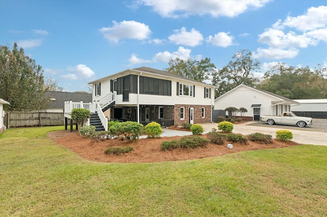 view of front of house with a sunroom and a front yard