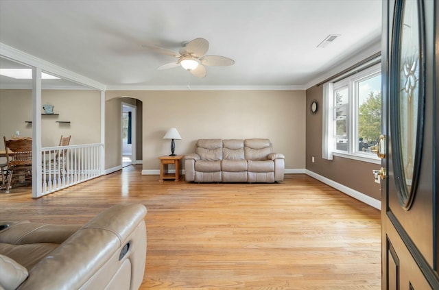 living room with light hardwood / wood-style flooring, ceiling fan, and crown molding