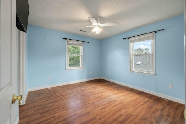 unfurnished room with a textured ceiling, dark hardwood / wood-style floors, and ceiling fan