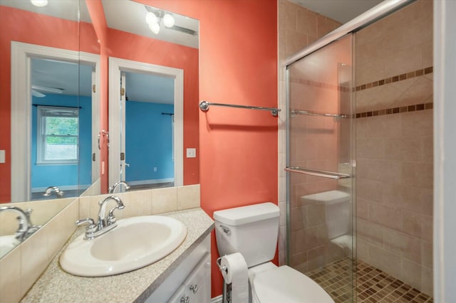 bathroom featuring vanity, toilet, and a shower with door