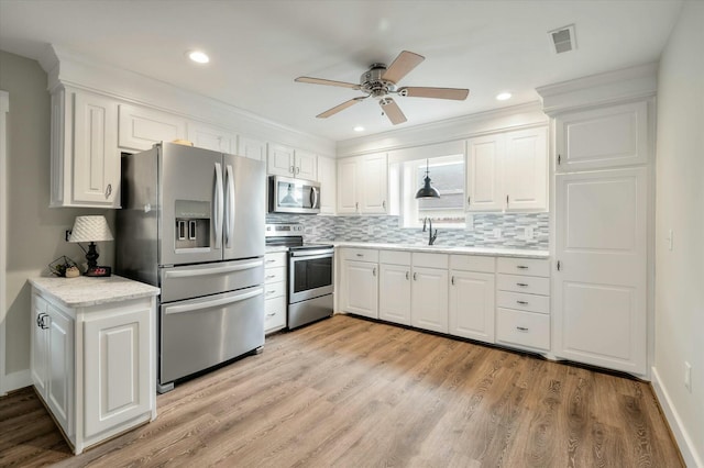 kitchen with white cabinets, stainless steel appliances, and light hardwood / wood-style floors