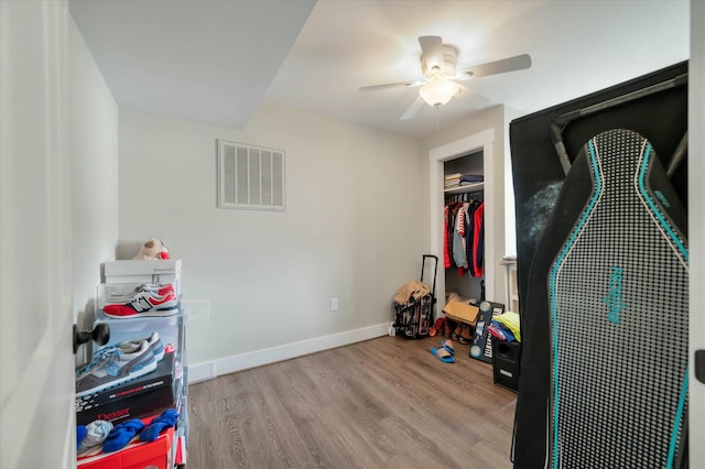 bedroom featuring ceiling fan, light hardwood / wood-style floors, and a closet